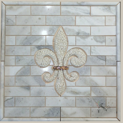 Stone mosaic fleur de lis on sahara carrara marble backsplash.